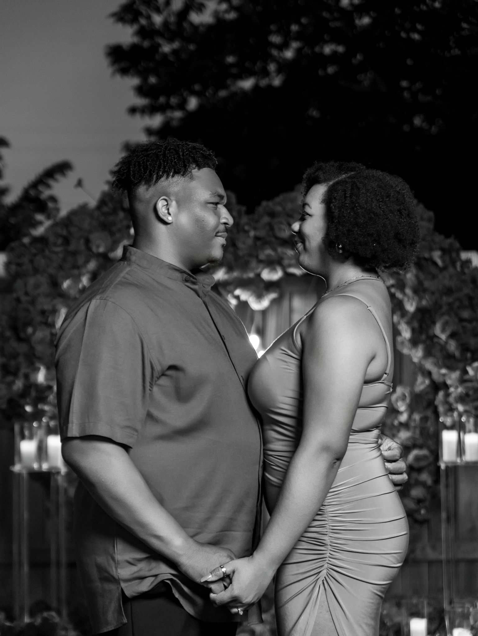 A tender moment captured in black and white during an evening proposal.