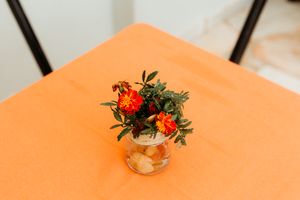 An elegant glass punch bowl with lemon slices and floral garnish sits on a navy floral tablecloth.