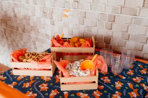 Colorful orange citrus peels scattered on a dark surface next to wooden boxes used for fruit sorting.