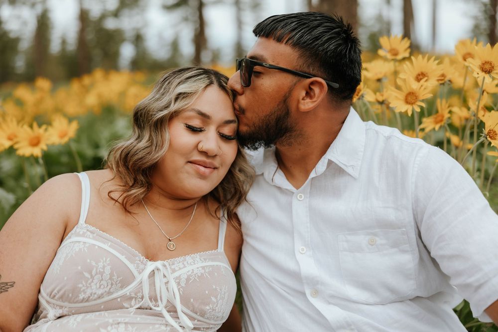 Romantic maternity portraits in a field of sunflowers at golden hour.