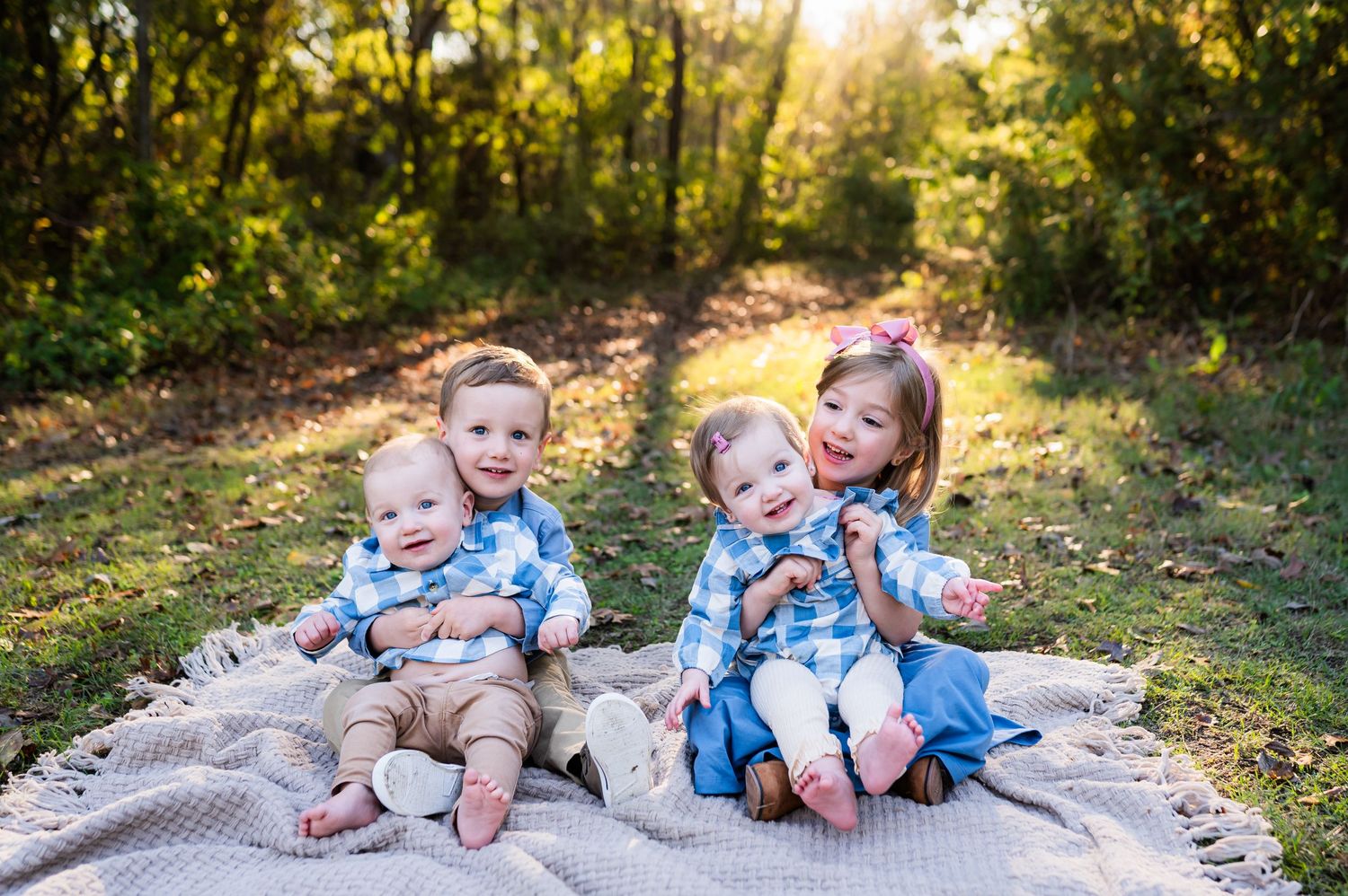 dallas outdoor fall family photos preschool aged big brother and sister hold infant twin babies in their laps