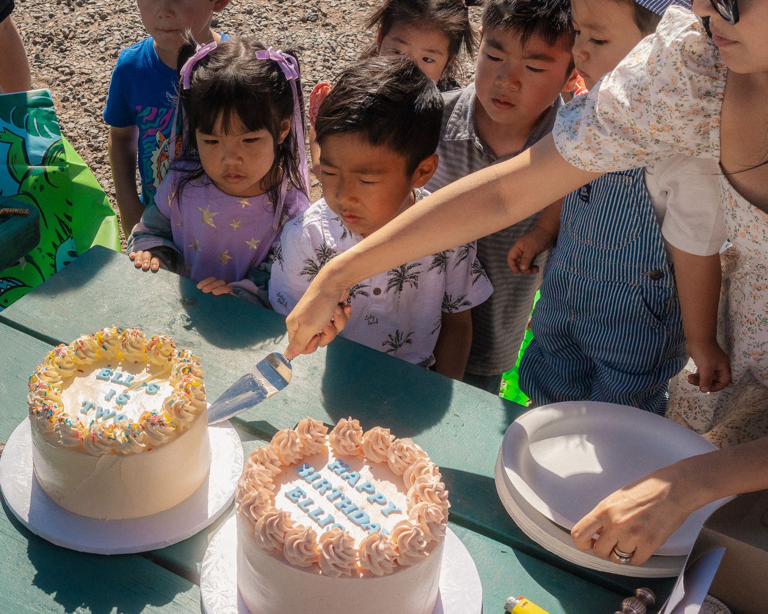 Children watching closely how a birthday cake is being cut, anxiously waiting for their slice -Newport Beach Family Photographer