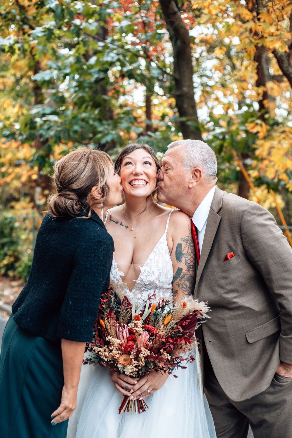 Autumn wedding photos showing sweet family moments with fall foliage in the background.