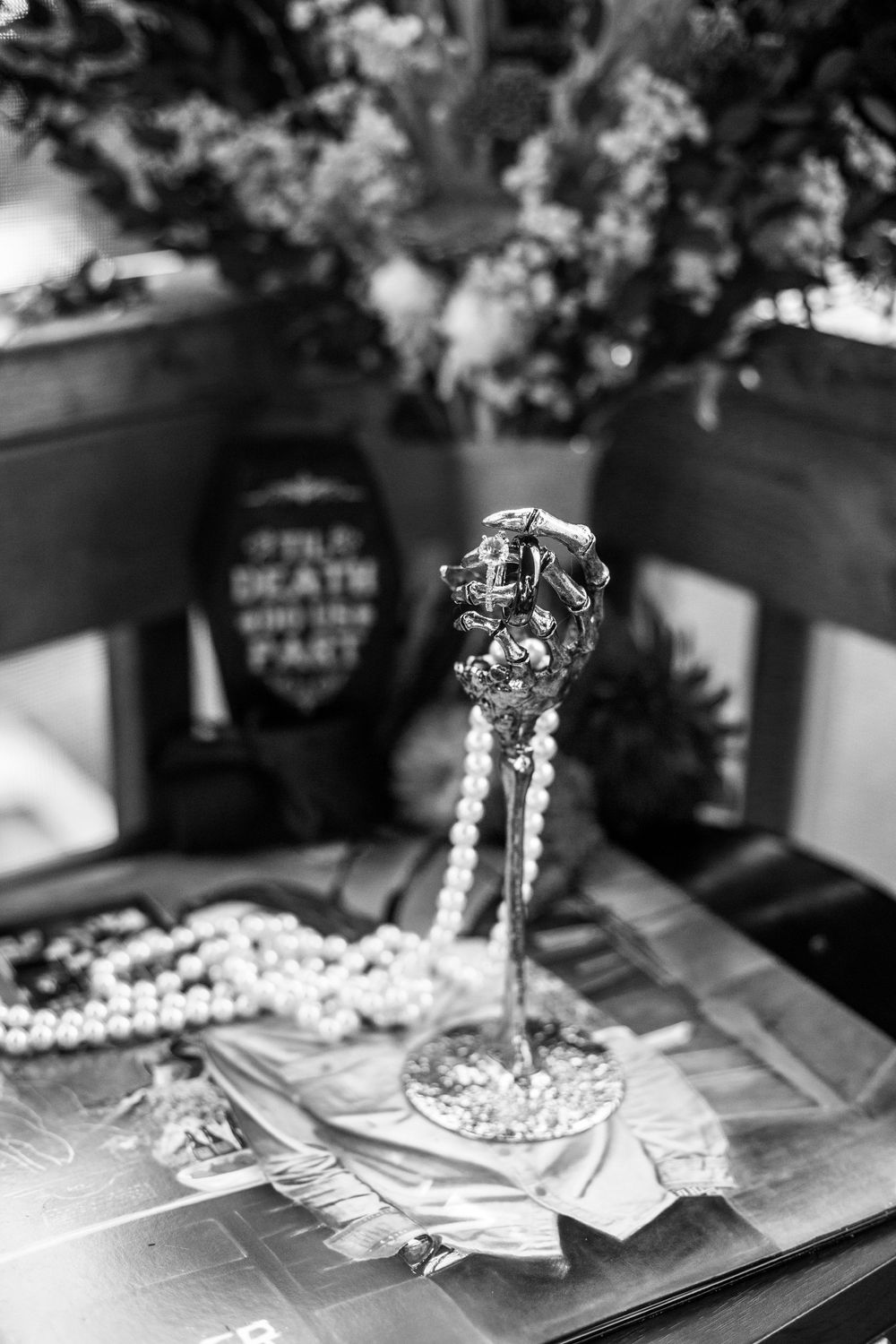 Elegant wedding decor featuring delicate pearl decorations and jewelry arranged on a reflective surface.