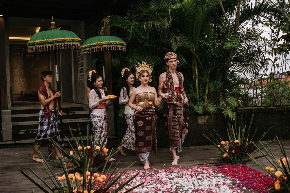 Wedding ceremony setup with green umbrellas and floral decorations in a tropical outdoor venue.