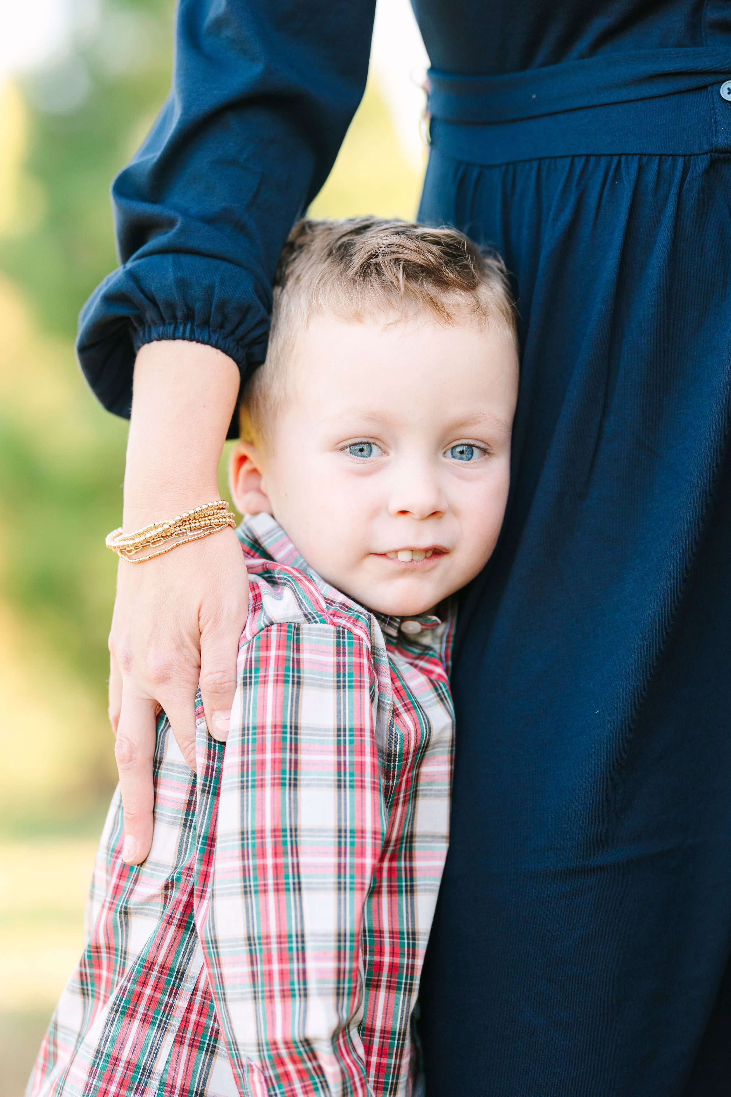 Close-up shots of a young child in plaid shirt standing next to someone in navy blue.