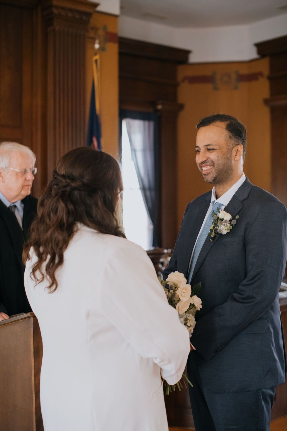 A series of intimate first look moments between a bride and groom in a warm-lit indoor venue.