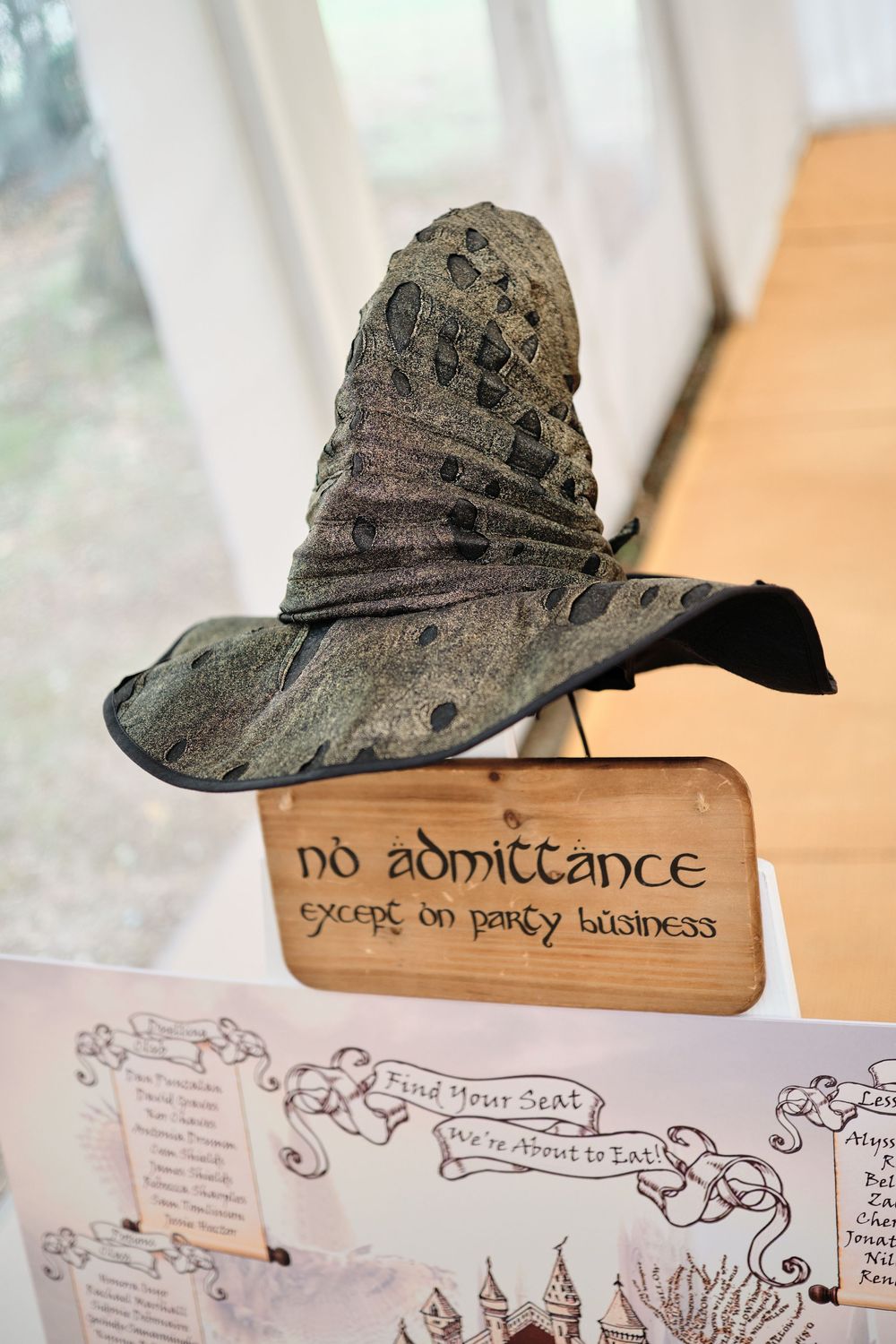 An old vintage hat rests above hand-drawn sketches and artistic illustrations on parchment paper.