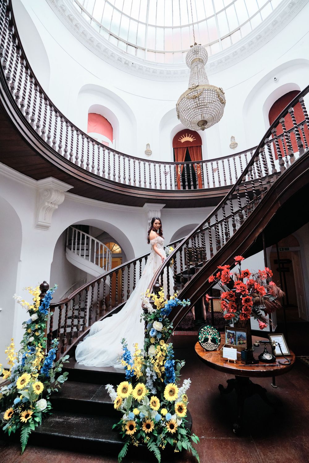 Beautiful staircase at an estate event venue with classic architectural details and yellow floral arrangements.