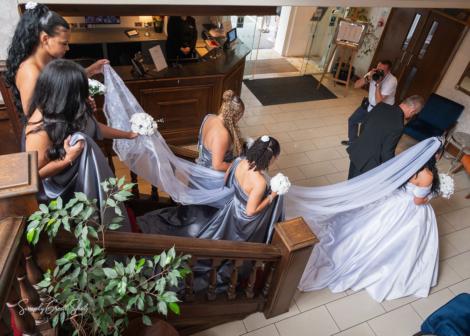 Southcrest Manor Hotel wedding photographer captures a bride and bridesmaids walking down the ornate staircase at Southcrest Manor Hotel.