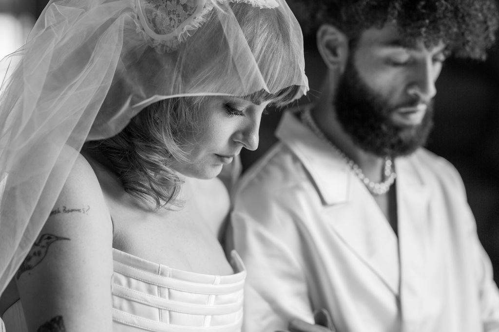 A series of black and white wedding photos showing tender moments between a bride and groom beneath a flowing veil.