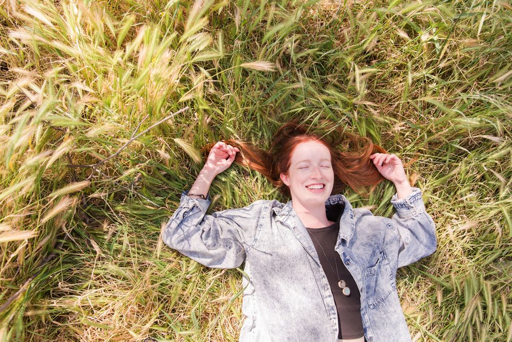 Casual outdoor portrait session in field with sunlit natural backdrop.
