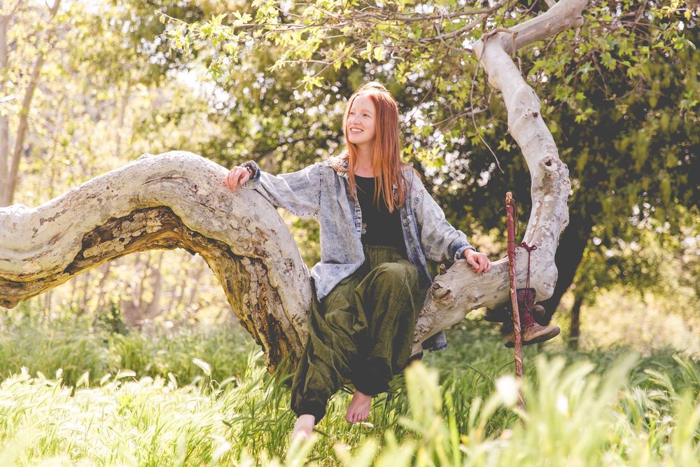 Artistic outdoor photoshoot under sprawling tree branches in natural light.