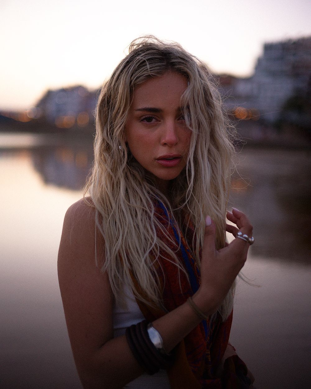 Artistic portrait series of a blonde figure at sunset against a waterfront backdrop.