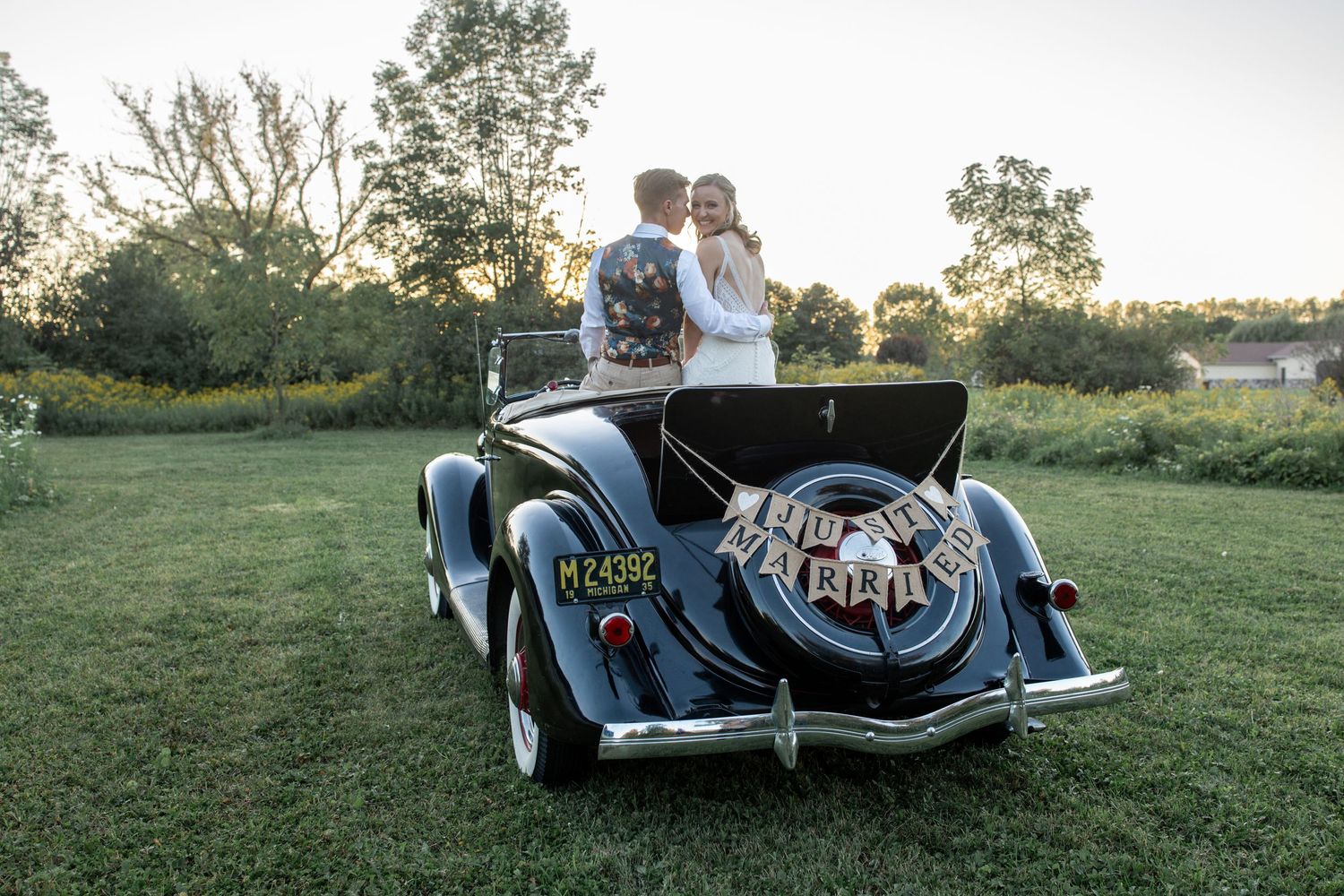 bride and groom in front of vintage classic car at 2gather more wedding venue in michigan