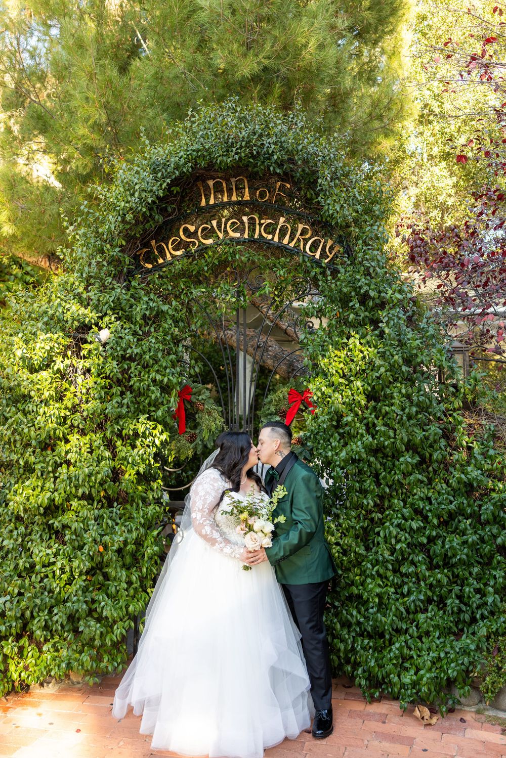A couple in formal wedding attire poses under a green garden archway through a multi-frame sequence.