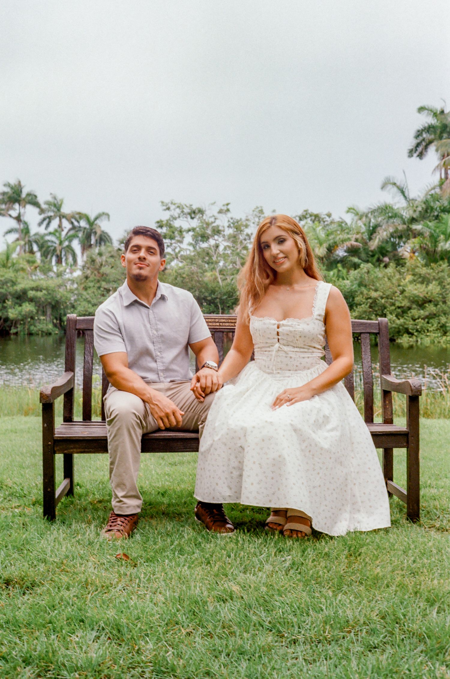 A couple walks down the church aisle after their wedding ceremony with a blue-lit stained glass window behind them.