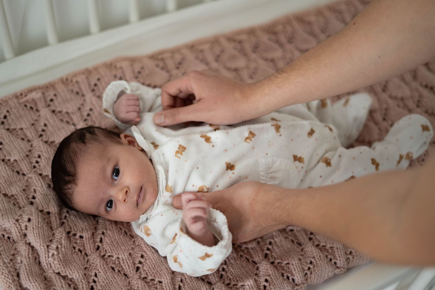 Nouveau-né dans sa chambre entouré des mains de son papa, à Saint-Germain-En-Laye