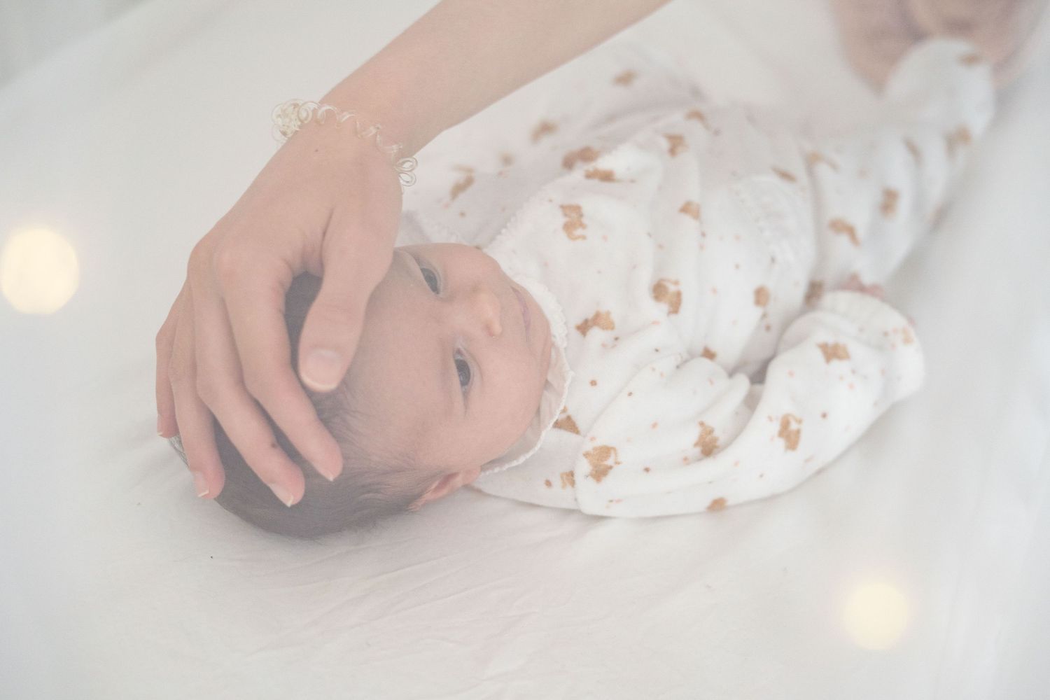 Bébé qui s'endort entouré de la main de sa maman,  à Saint-Germain-En-Laye