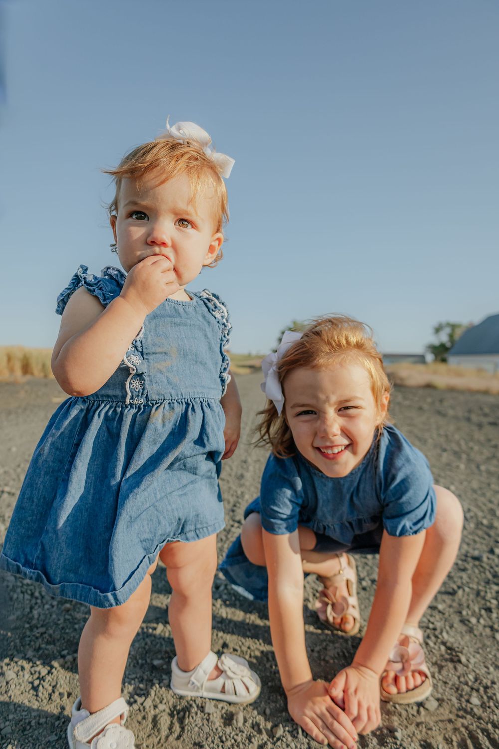 Playful children in blue denim outfits having fun on rocky terrain.