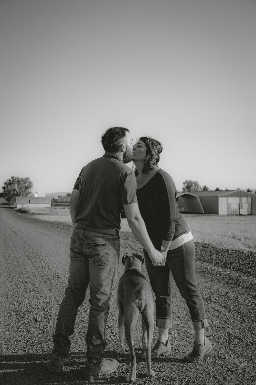 Black and white photo of family members embracing outdoors.