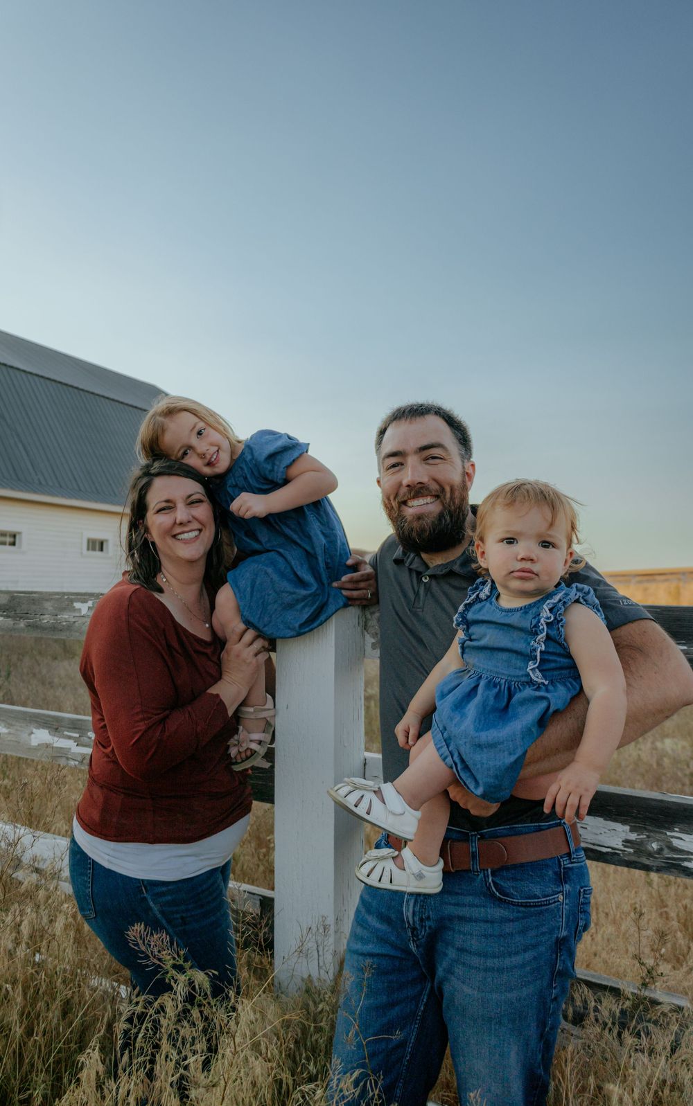 Candid family moment with playful interactions against rural backdrop.
