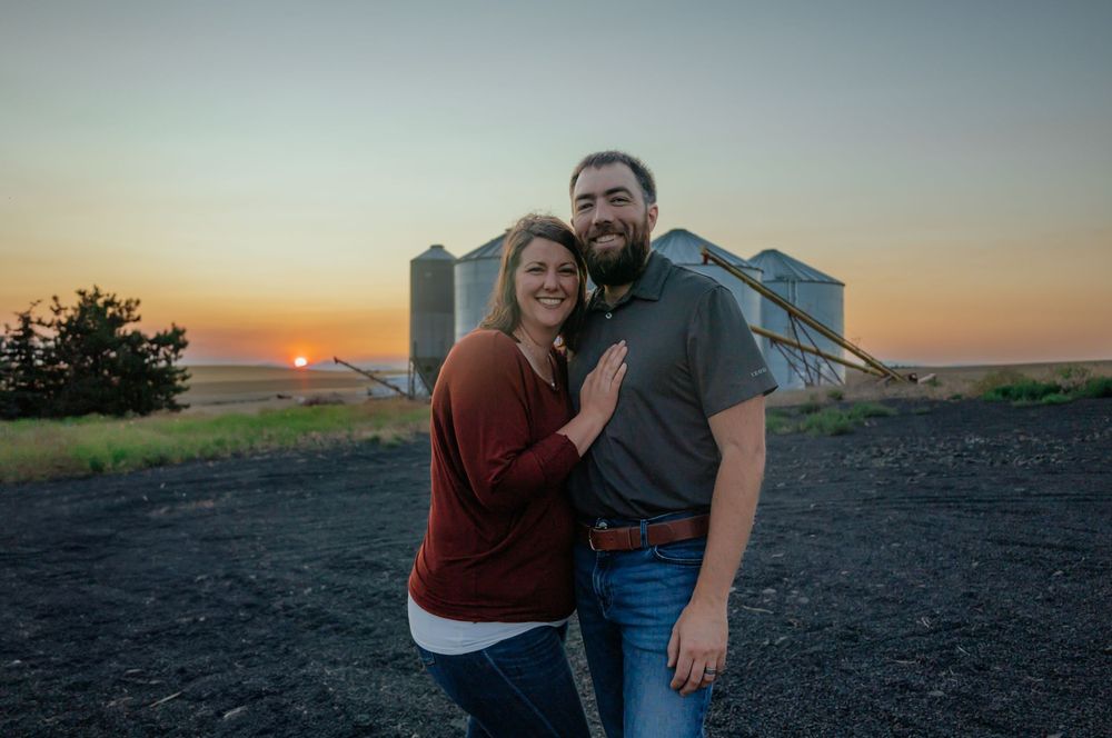 Romantic sunset photoshoot with farm silos in background.