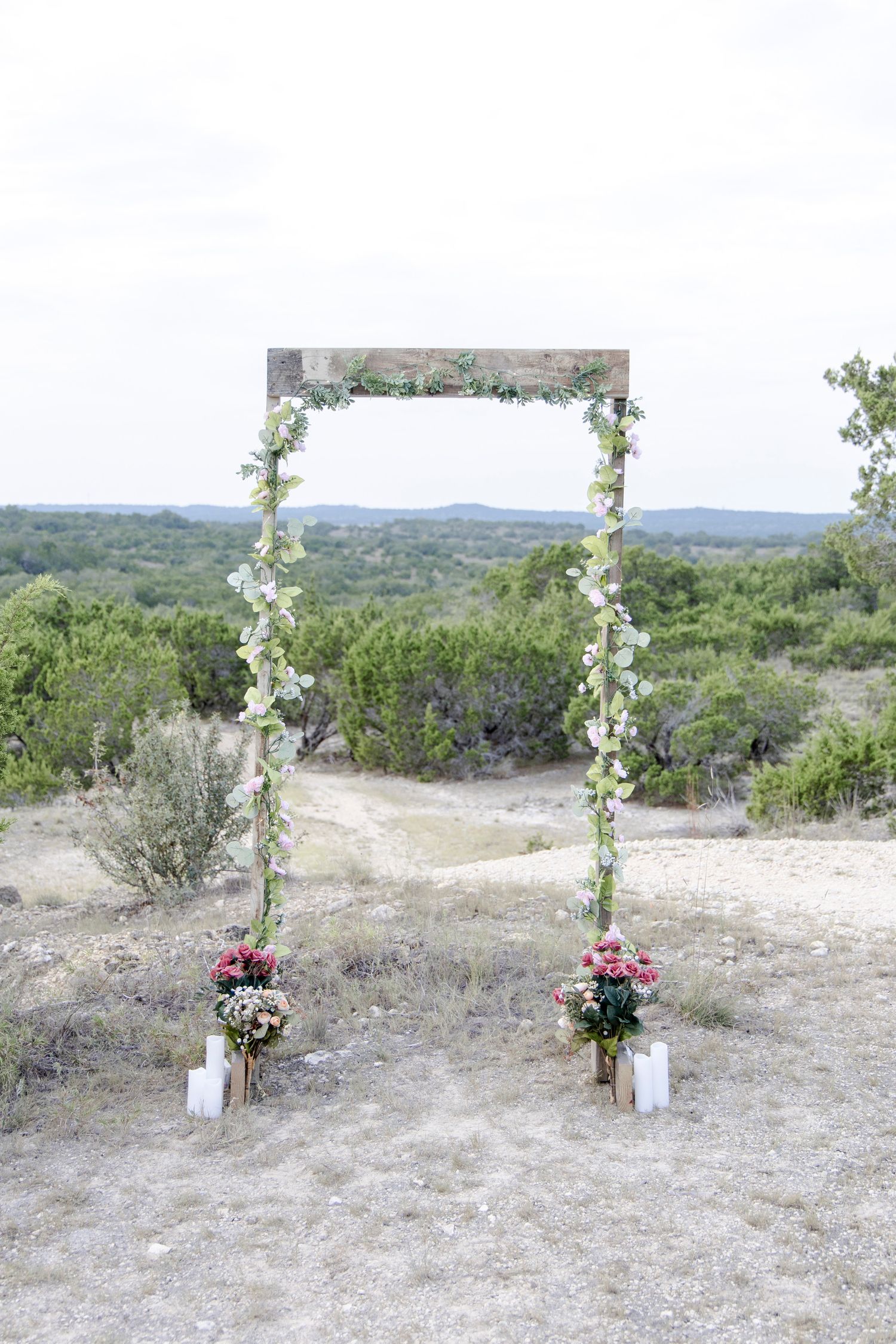 Candlelit walkway leading to a decorated arch for a surprise engagement proposal in Dripping Springs, Texas Hill Country.