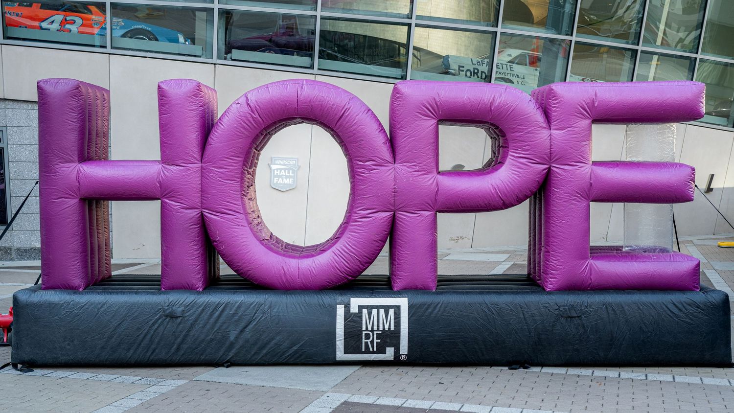 Large inflatable purple HOPE letters display on pavement, bold motivational public art installation.