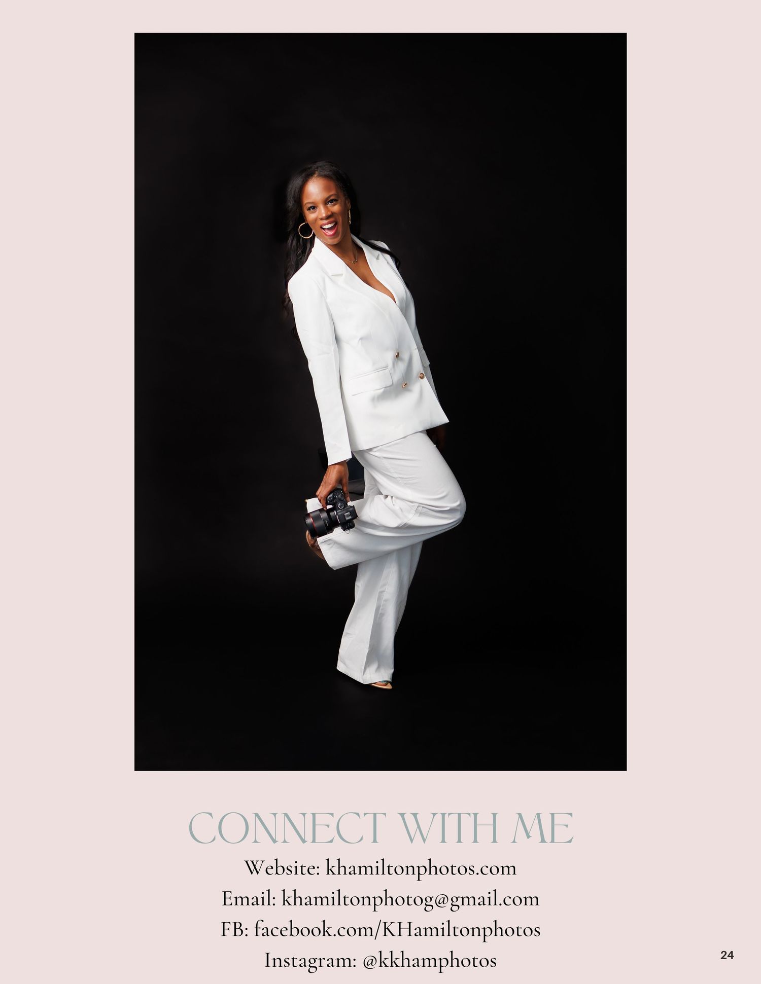 Woman in white suit posing confidently against dark background, holding camera, promoting KHamilton Photos photography services.