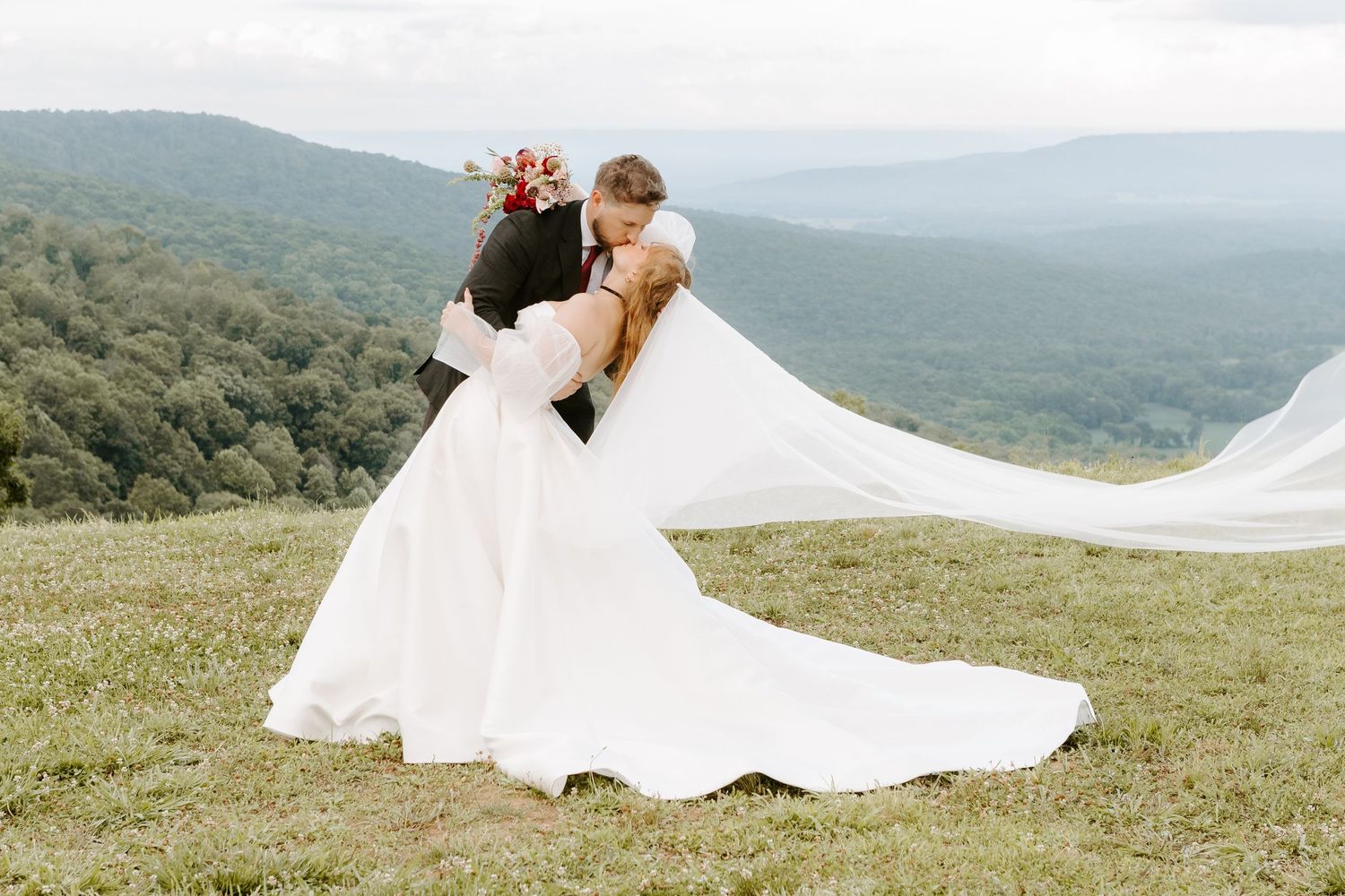 Bride and groom share a romantic moment at golden hour in a lush green farm field at sunset.