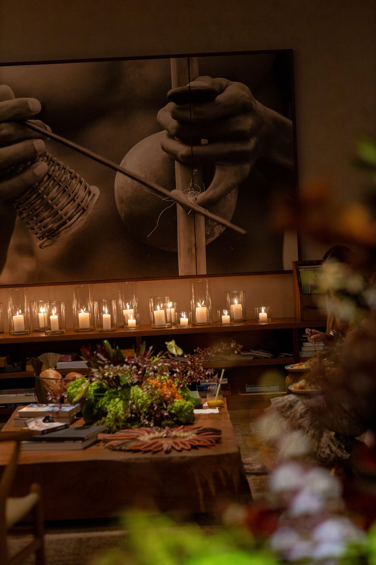 Romantic candlelit wedding reception table with floral centerpiece and black-and-white artisan photography backdrop.
