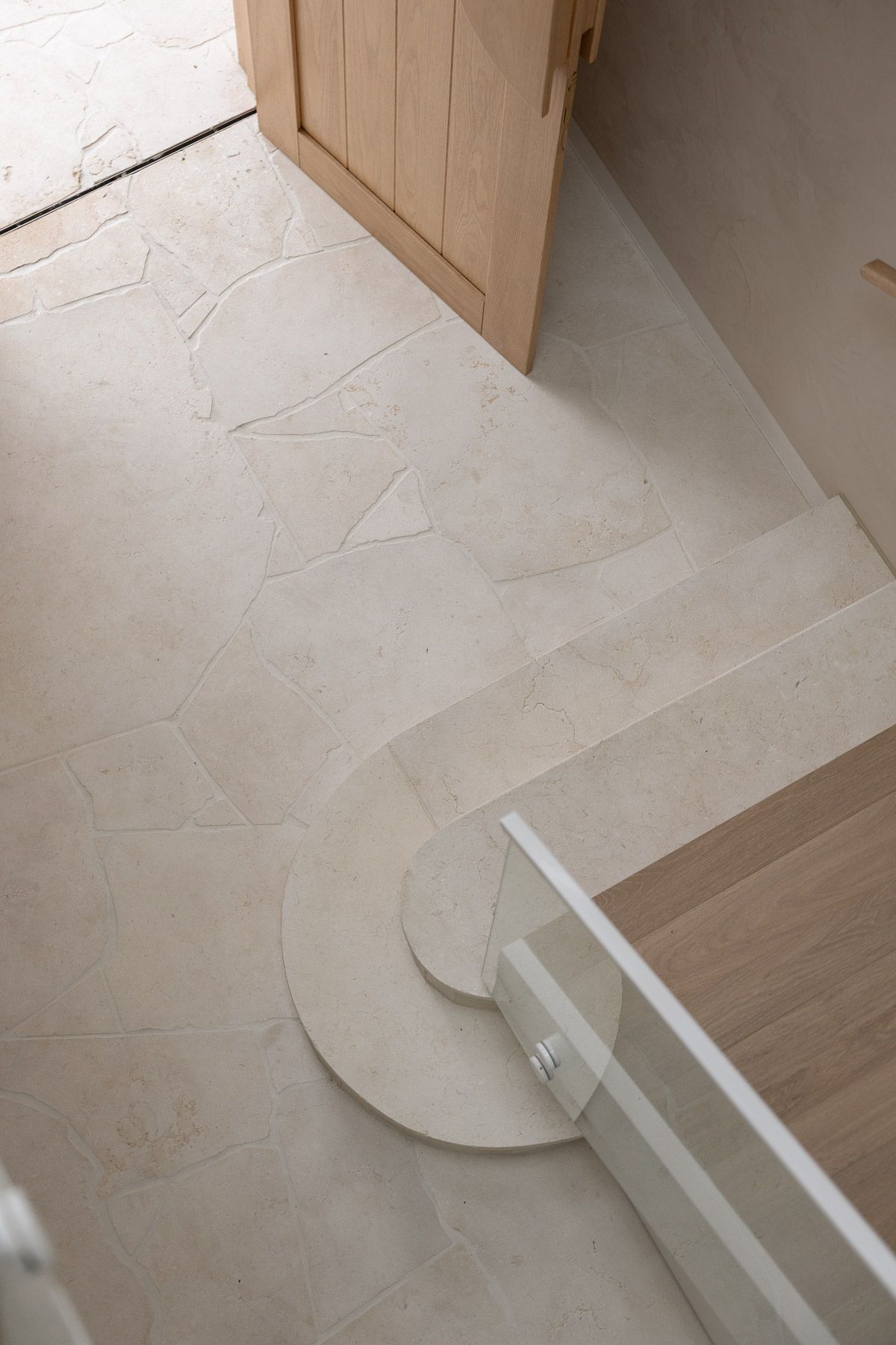 Interior detail photography showcasing curved staircase design and natural stone flooring in Miranda NSW.