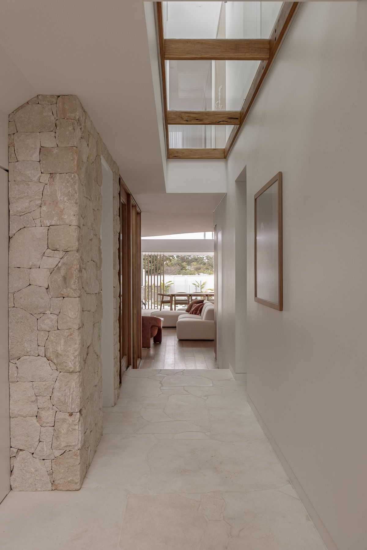 Architectural hallway photography showcasing natural light, skylights and textured stone detailing in Miranda NSW.
