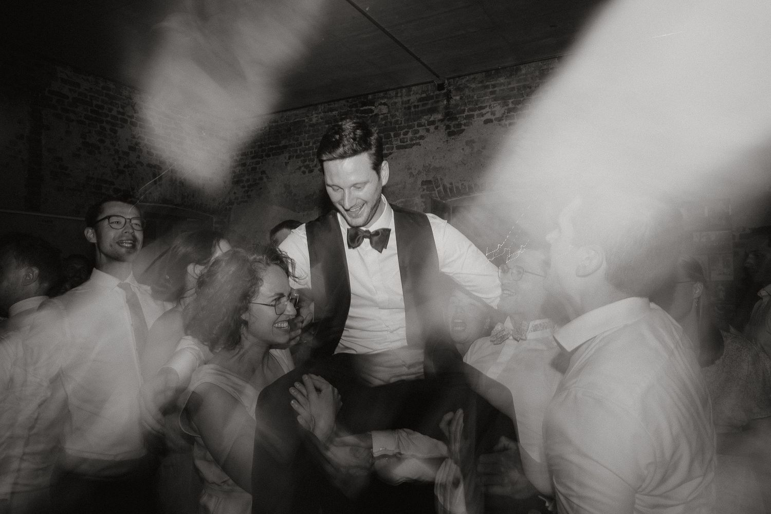 Black and white photos of couples dancing and celebrating at a wedding reception.