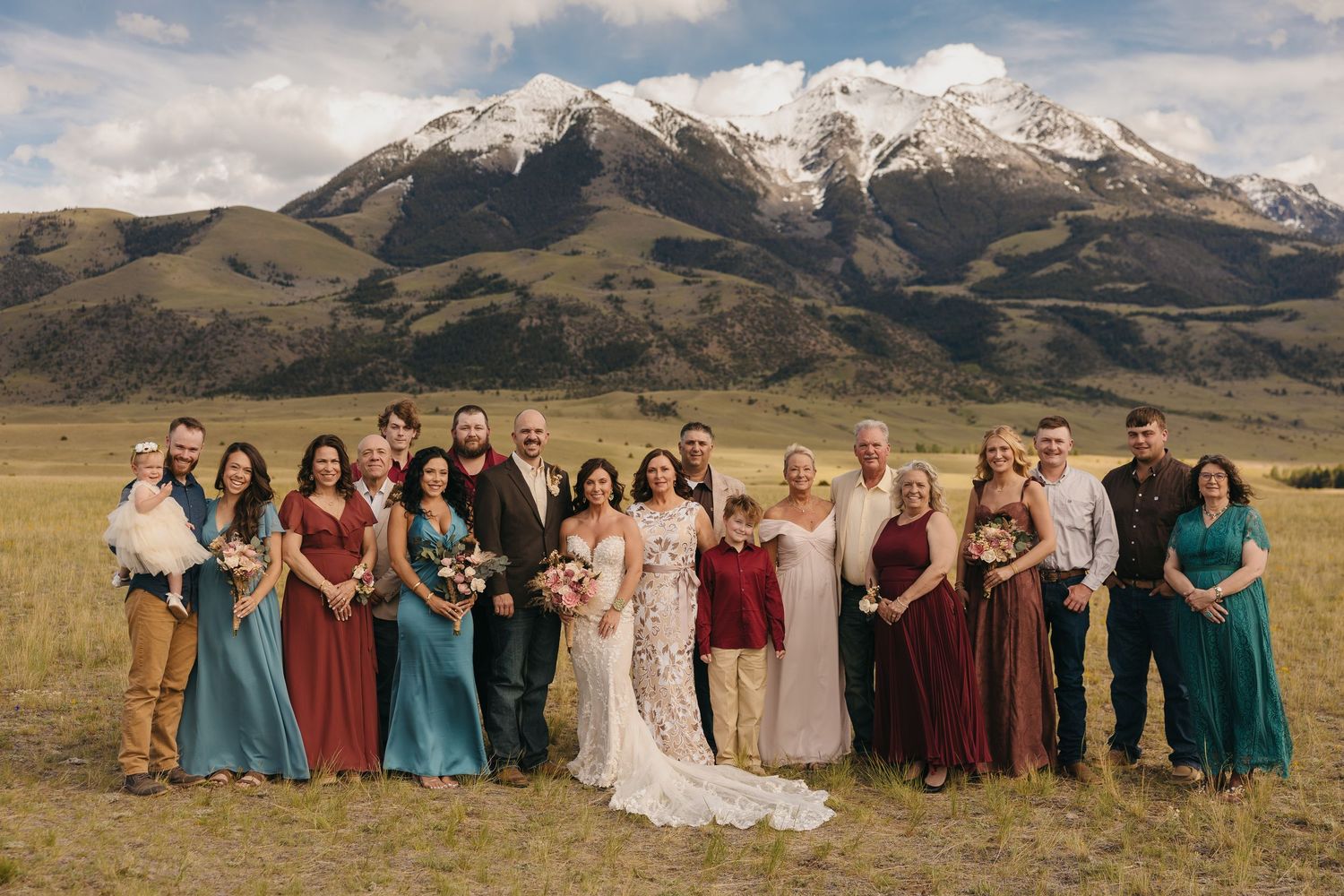 Intimate Wedding Guests Pose with Bride and Groom in Pray, Montana under the snow peaked mountains at a May Chico Wedding. Photographer