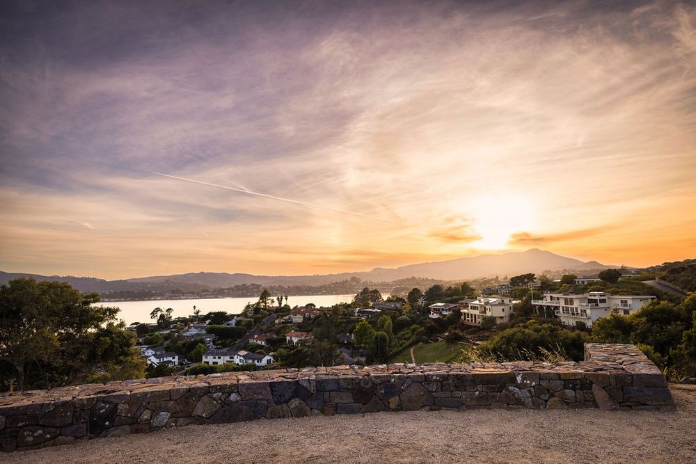 Panoramic sunset view over Tiburon hillside neighborhood with San Francisco Bay in the background.