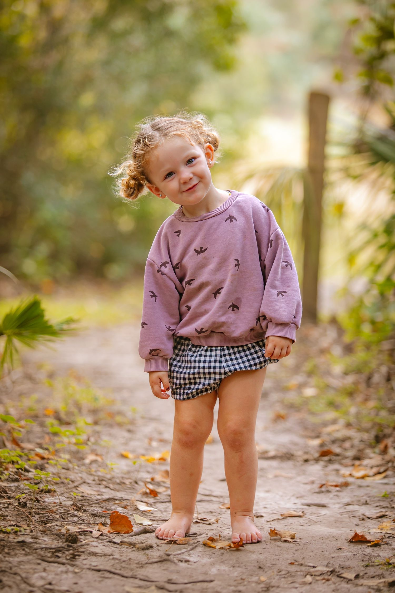 A joyful moment captured on a nature trail with bare feet and a patterned outfit.