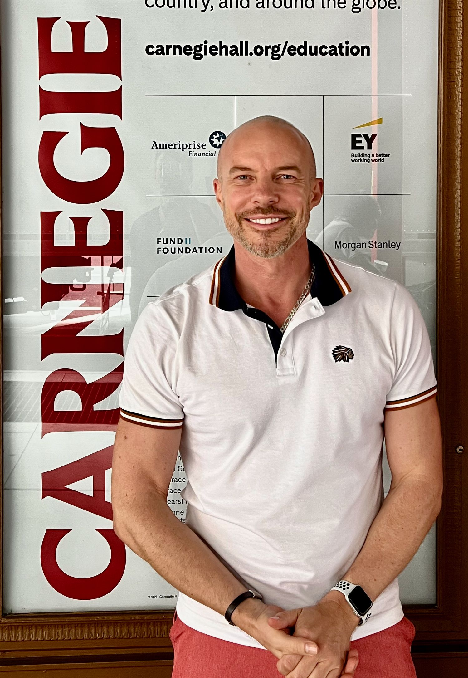 Photographer Gary Williams in front of Carnegie Hall banner with sponsors.