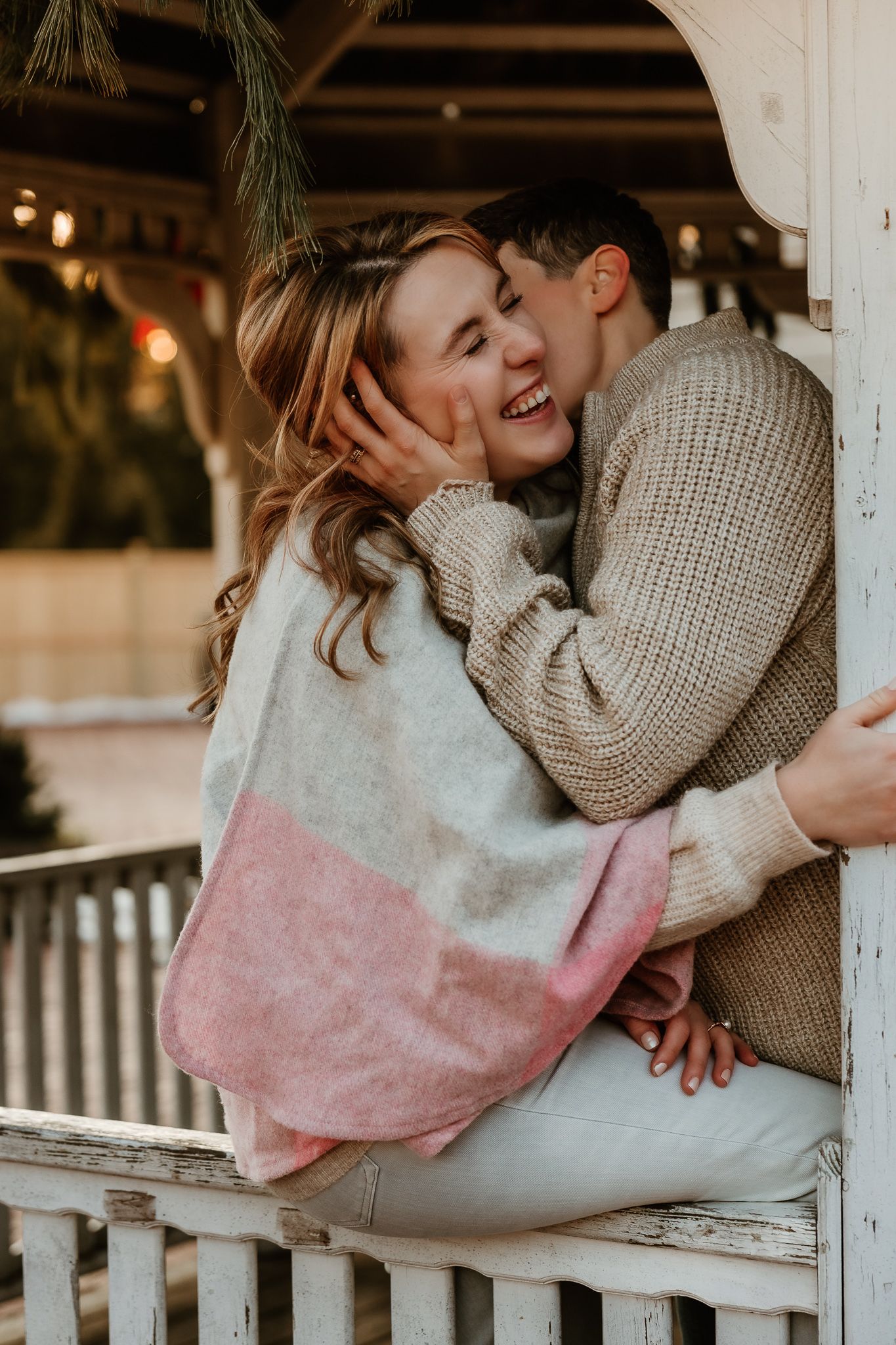 lesbian couple kissing and laughing in a pavilion in front of heirloom market in old Wethersfield, Connecticut.