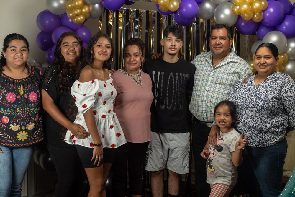 Family gathering with purple and gold balloon decorations.