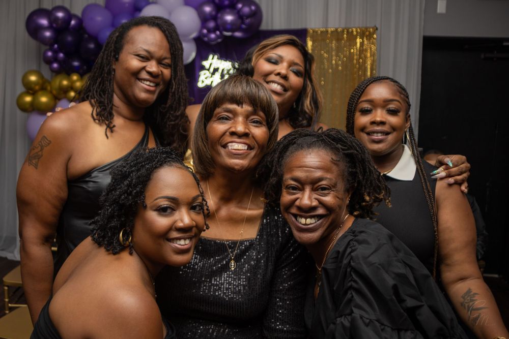Group celebration photo with friends in formal black attire.