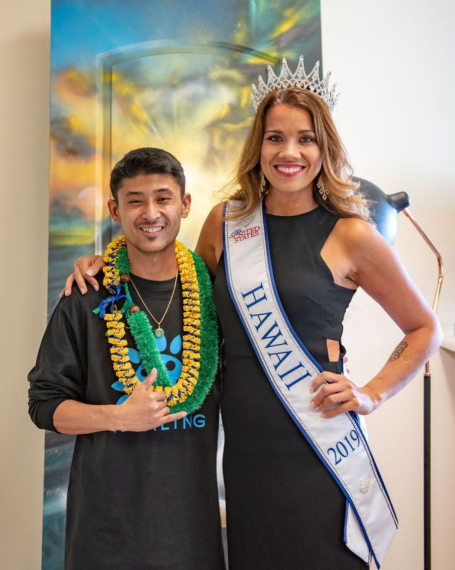 A celebration moment captured against a colorful backdrop featuring formal attire and pageant regalia.