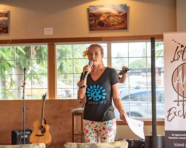 Bright cafe interior with guitars on display and large windows overlooking palm trees.
