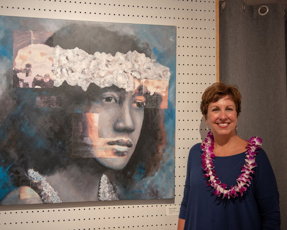 Art exhibition features large contemporary portrait painting on pegboard wall.