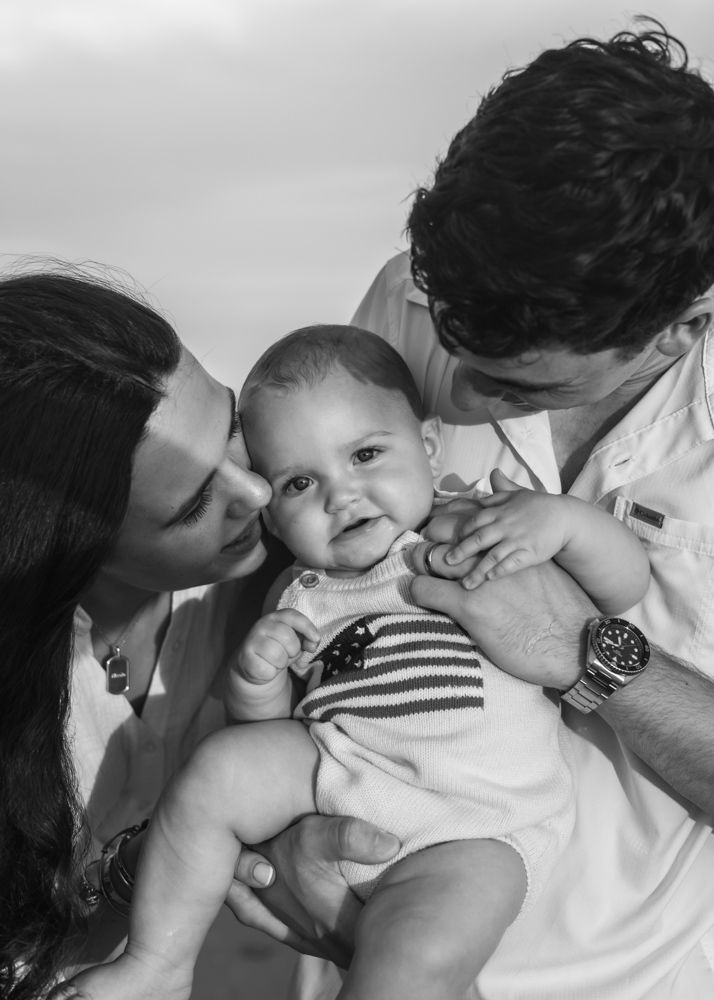 Black and white portrait of siblings sharing playful moments outdoors.