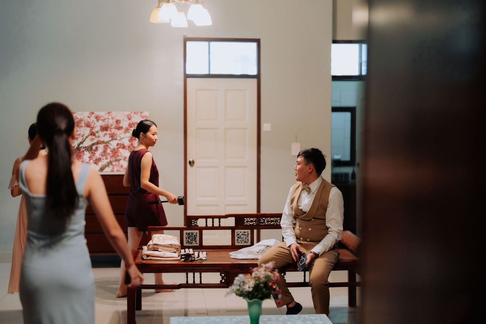 People having a casual conversation while sitting in a bright room with natural light streaming through windows.