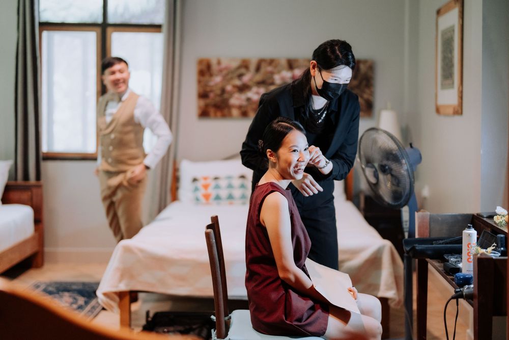 Professional hairstylist wearing protective mask while styling client's hair in a salon interior.