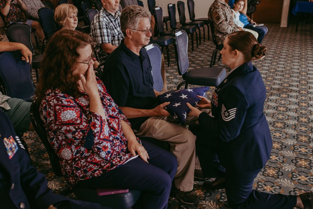 daughter presenting father American flag at Air Force retirement ceremony, documentary family photography, Whitney Popp
