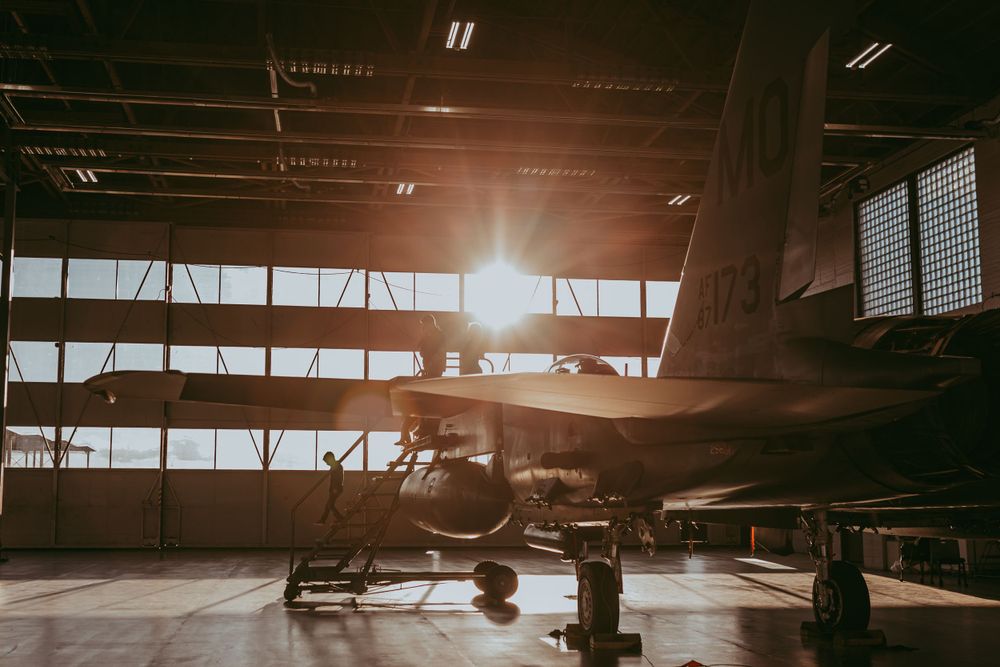 family on fighter jet in hangar.